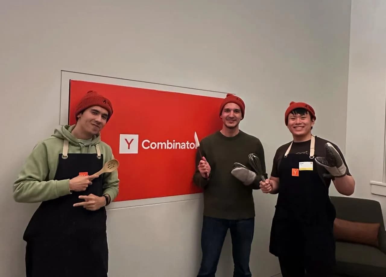 Javokhir Shomuratov with teammates Mark Morgan and Oscar Hong in front of the Y Combinator sign after winning HackTheStackathon